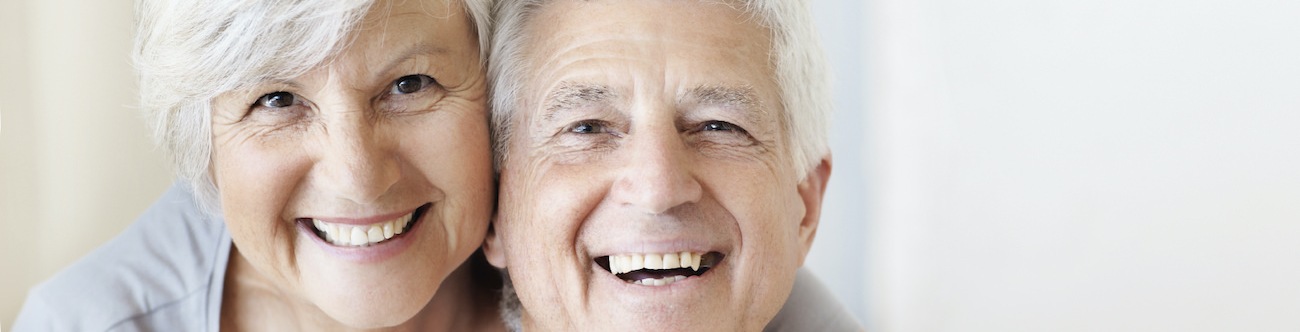 Older couple smiling and posing in a bright room